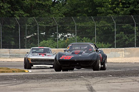 70s Stingray Racing corvettes on track, vintage Chevrolet Corvette at speed.
