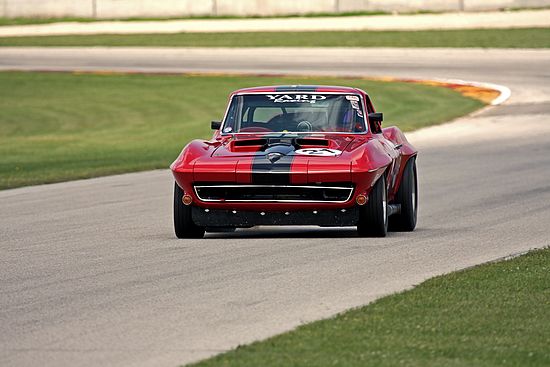Red and Black Vintage Chevrolet Corvette at speed.
